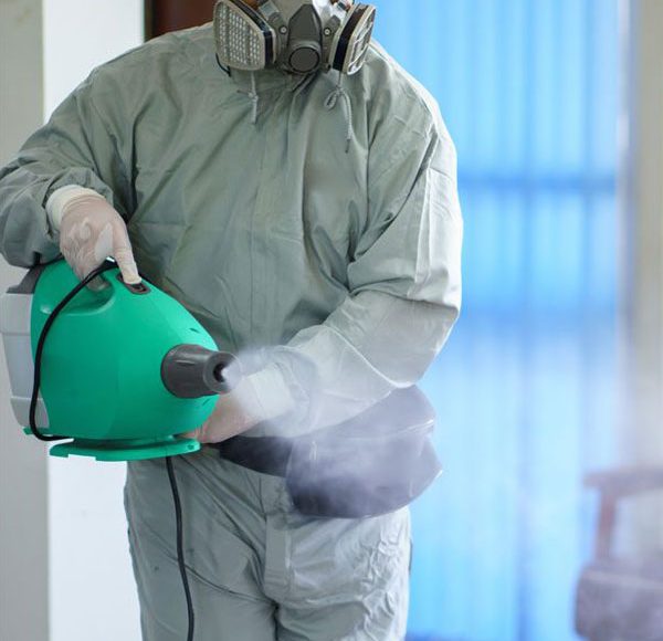 man spraying cleaner on a surface