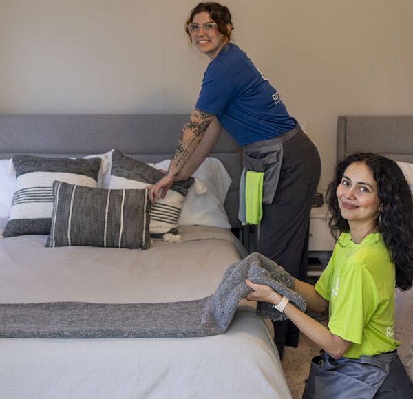 two women tidying up a bedroom
