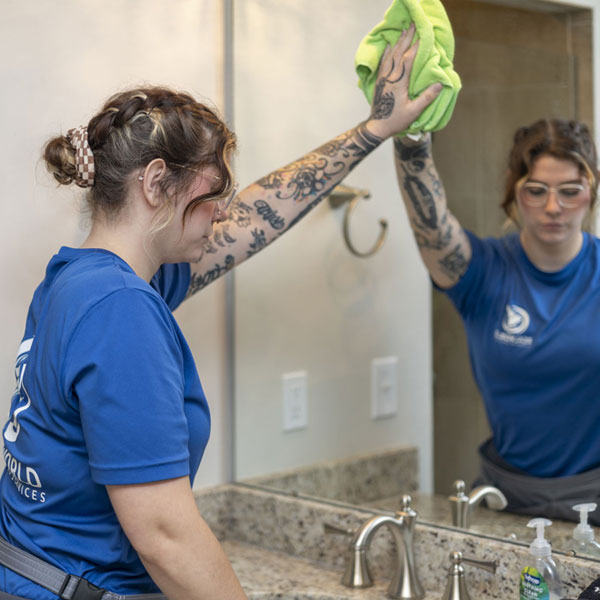 woman cleaning a mirror
